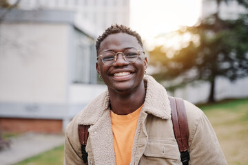 Portrait Of Positive Happy African American Male Student Standing In University campus 