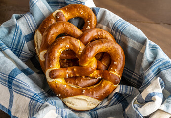 Group of brezels or pretzels in bread basket with napkin 