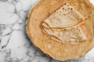 Delicious crepes on white marble table, top view