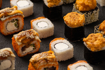 Sushi rolls in rows solid pattern on black background macro