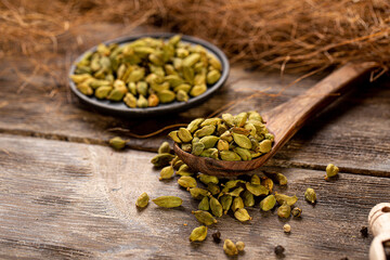 Cardamom spice seeds on the wooden background