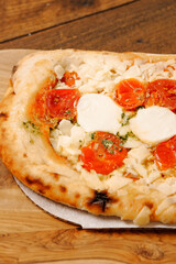 Premium high quality pizza with mozzarella cheese and tomato. Italian style dish with top products. Close up.