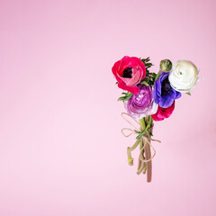 Purple, pink, violet and white flowers arranged in a bouqet floating above light pink backgorund. Minimal summer floral concept.