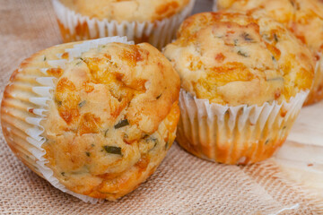 cheese and herb savory muffins baked to cheesy perfection on a rustic surface