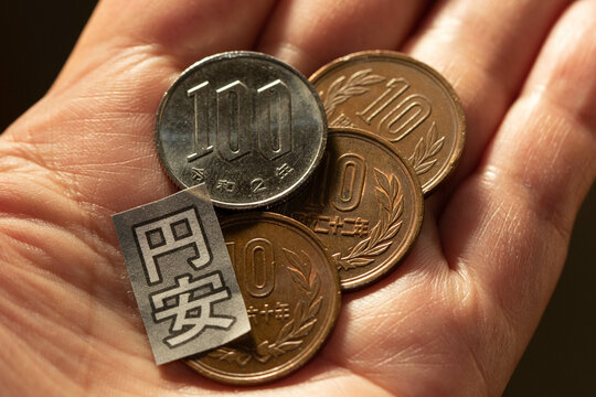 手のひらの上の日本円の硬貨と円安イメージ