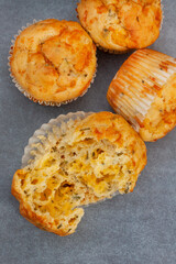 cheese and herb savory muffins baked to cheesy perfection on a mottled grey surface