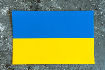 Ukraine national flag on gray concrete cement surface background. Place for text. War in Ukraine