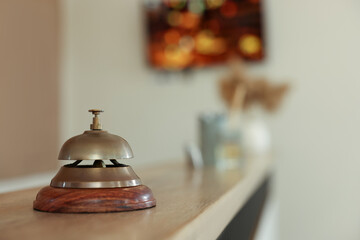 Hotel service bell on wooden reception desk. Space for text