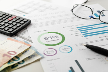 Naklejka na ściany i meble Investments financial charts with pen, calculator, eyeglasses, euro banknotes