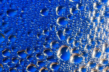 Water drops on a blue glass surface exrtreme close-up view