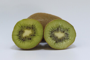 whole and halved kiwi fruits on a white background