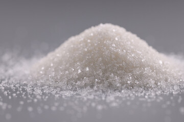 Pile of sugar crystals on grey surface, heap of sweet powder to add in dishes