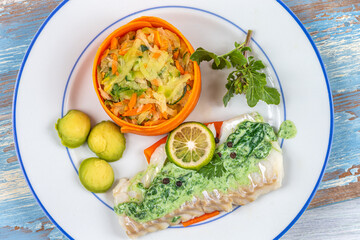 Plate of cod and vegetables with sorrel sauce
