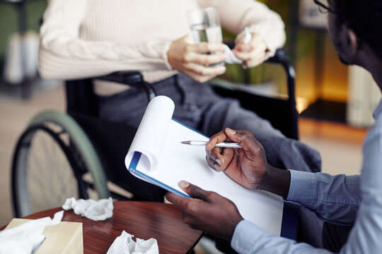 Close-up Image Of Psychiatrist Filling Document When Talking To Patient With Disability In Private Session