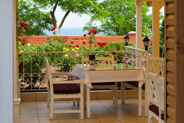Sea view from cafe terrace with wooden table and chairs