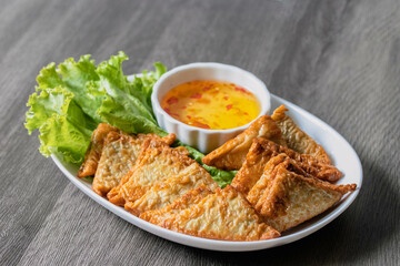 Triangular fried tofu eating with spicy dipping sauce, sweet and spicy