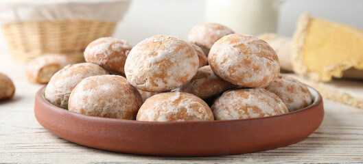 Plate with tasty homemade gingerbread cookies on white wooden table, closeup. Banner design