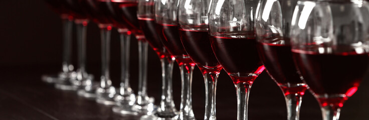 Glasses with tasty red wine, closeup view. Banner design