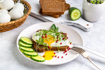 Sandwich with scrambled eggs, microgreens and pink pepper on a plate. Delicious and healthy snack