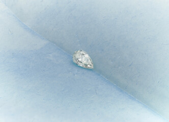 Pear-Shaped Diamond with Tweezers on Blue Background