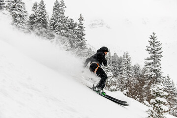 skier quickly slides down the snow-covered mountain slope.