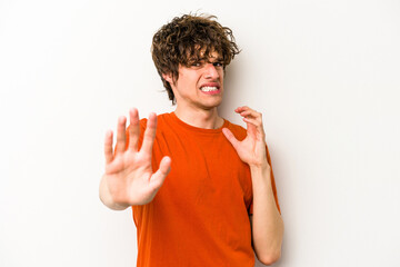 Young caucasian man isolated on white background being shocked due to an imminent danger
