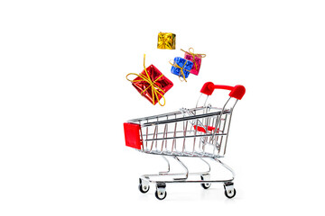 Miniature shopping cart and  gift box isolated on white background.
