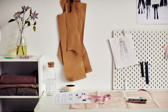 Workplace of fashion designer or tailor with sewing patterns, fashion sketches and stationery