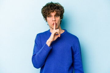 Young caucasian man isolated on blue background keeping a secret or asking for silence.