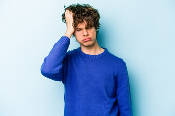 Young caucasian man isolated on blue background tired and very sleepy keeping hand on head.