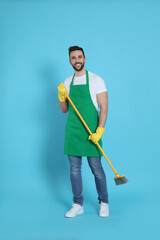 Man with yellow broom on light blue background