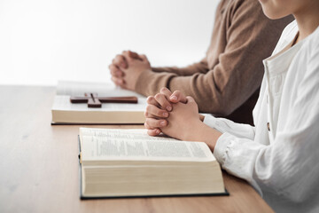 Father and daughter siting by desk and reading a holy bible