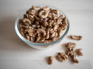 Roasted walnut and cashew, lie in a plate on the table. Protein, useful nuts. Nut Mix