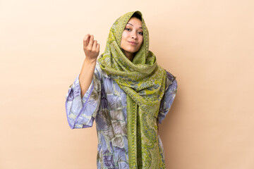 Indian woman isolated on beige background making Italian gesture
