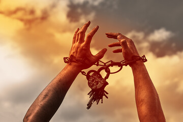Male hands chained close-up. Chain with a lock on the hands. Addicted person. The prisoner is a man.