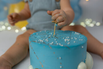 the first cake.  the child takes the cake with his hand. hand in pastry cream. children's holiday