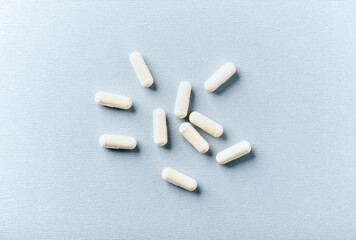 Selenium capsules. Concept for a healthy dietary supplementation. Bright paper background. Soft focus. Top view. Close up. Copy space.