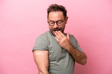 Middle age man wearing a band aids isolated on pink background with surprise and shocked facial...