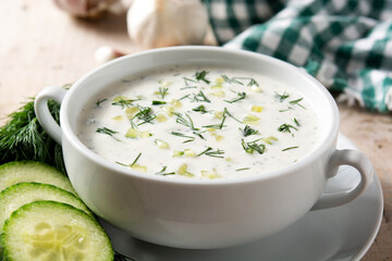 Bulgarian tarator sour milk soup in bowl on wooden table	