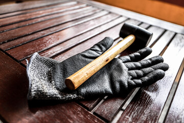 
Worker in his work area with a computer, gloves and a mallet hammer