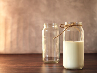 healthy drink milk in a glass jar on a beige background