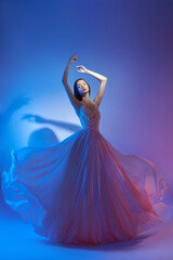 Art fashion beautiful elegant woman in blowing flying dress. Freedom concept in neon color light....