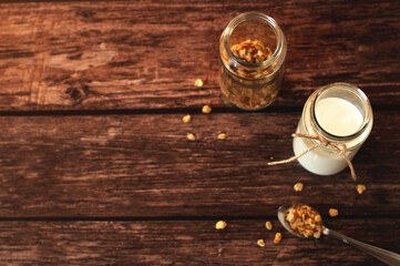 fermented milk product kefir in a glass jar with granola on a beige background
