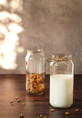 fermented milk product kefir in a glass jar with granola on a beige background