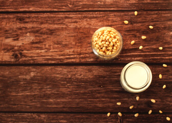 Fototapeta na wymiar fermented milk product kefir in a glass jar with pine nuts on a beige background