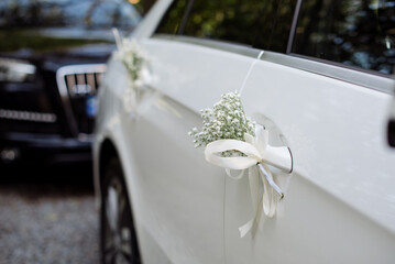 White car in a wedding procession beautifully decorated with flowers
