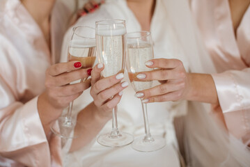 Bride and bridesmaid drinking champagne together. Closeup