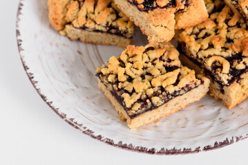 Bakery. Square cookies with jam on a white plate. White plate with cookies in the upper right corner. Place for text