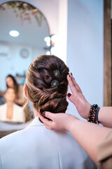 Hairdresser finishing a stylish hairstyle for a client in the beauty salon.