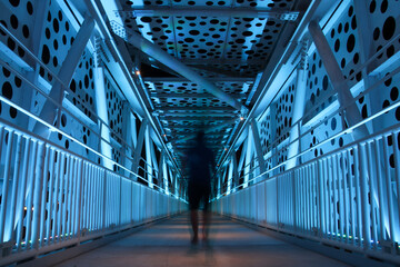 Interior design of  Illuminated  pedestrian bridge with a motion of man walking away 